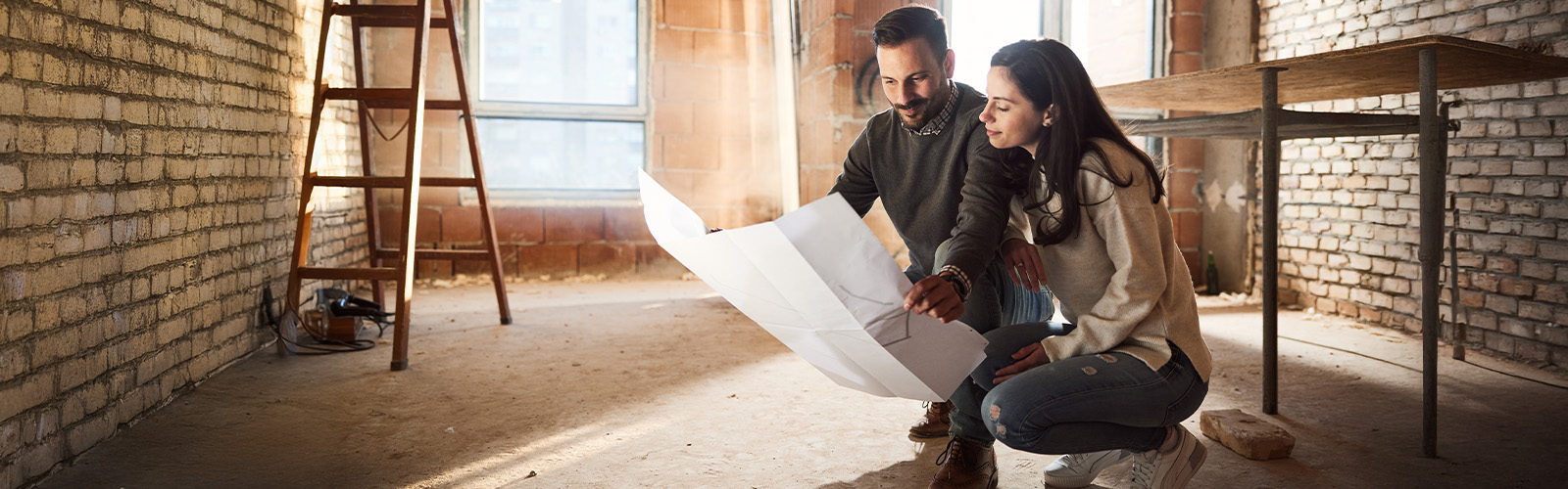 Couple looking at blueprints for their home under construction