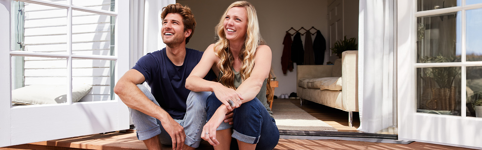 Young couple sitting on the porch of their home