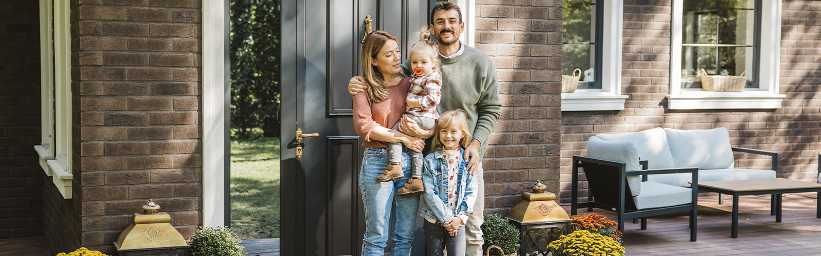 Family standing in front of their new home