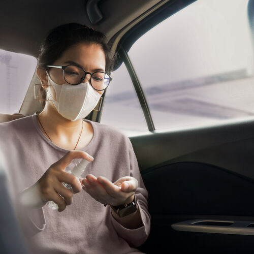 一位女士在車內戴著 HOYA Hi-Vision 抗菌鍍膜眼鏡進行雙手消毒