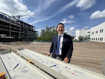 Moffitt President and CEO Patrick Hwu, MD, signs the beam before it is placed atop the Moffitt Discovery & Innovation Center.
