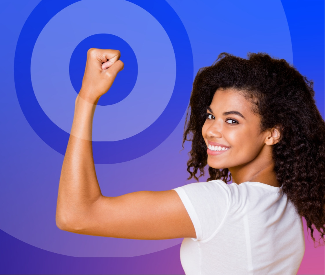 Query successfulA smiling woman with curly hair, wearing a white t-shirt, stands in front of a blue and purple gradient background with circular overlays. She is flexing her right arm, symbolizing strength or empowerment, and looking over her shoulder toward the viewer.