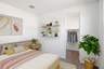 bedroom with a spacious bed, oak nightstands, and indoor plants