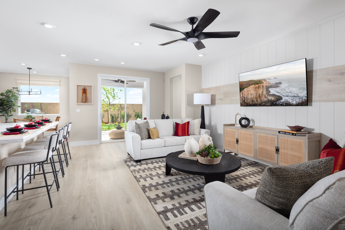 great room with light wood floors and white sofas