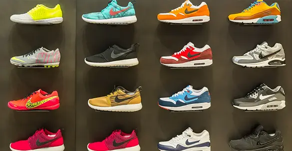 A wall of adidas trainer shoes/sneakers on a black shop wall, various different colours 