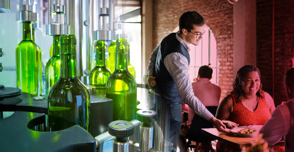 The left shows a bottling factory and the right shows a waiter attending to a couple seated at a restaurant table