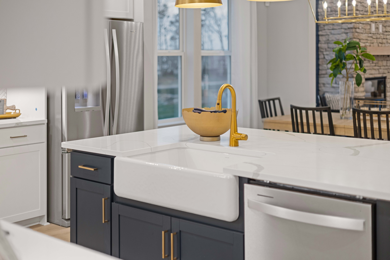 kitchen with blue cabinets, farmhouse sink, and gold hardware