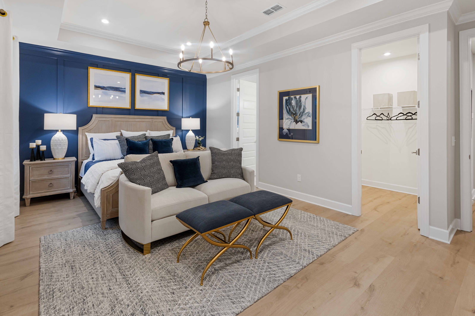 primary bedroom with blue accent wall and tray ceiling