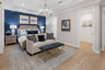 primary bedroom with blue accent wall and tray ceiling
