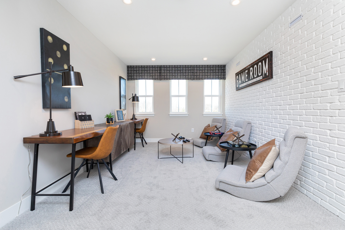 second-floor loft with windows and neutral carpet 