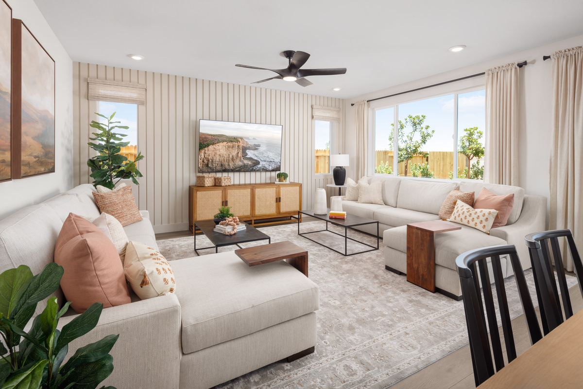 room with two tan sofas, and black tables