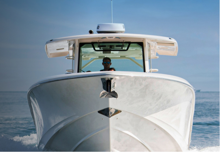 Bows of a large powerboat with onboard Fathom e-power system speeding towards you