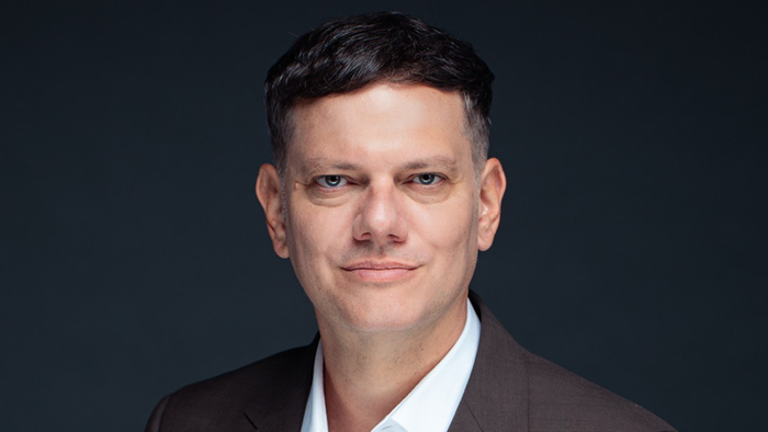 A portrait image of Maxfield Weiss, facing forward and smiling at the camera