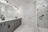 primary bathroom with double sink vanity, gray cabinets, and matte black fixtures