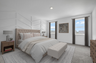 primary bedroom with carpet flooring, large windows, and a white accent wall