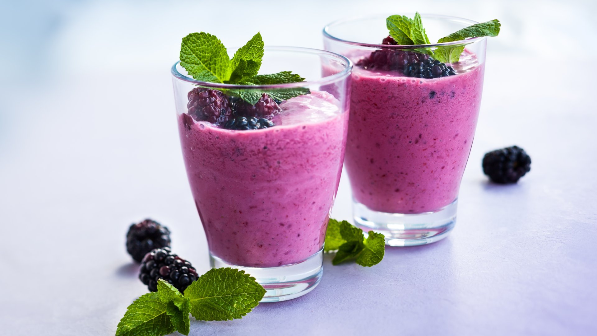 Nutrition Australia's Dairy Free Berry Delight Smoothie served in glass with fresh blueberry's 