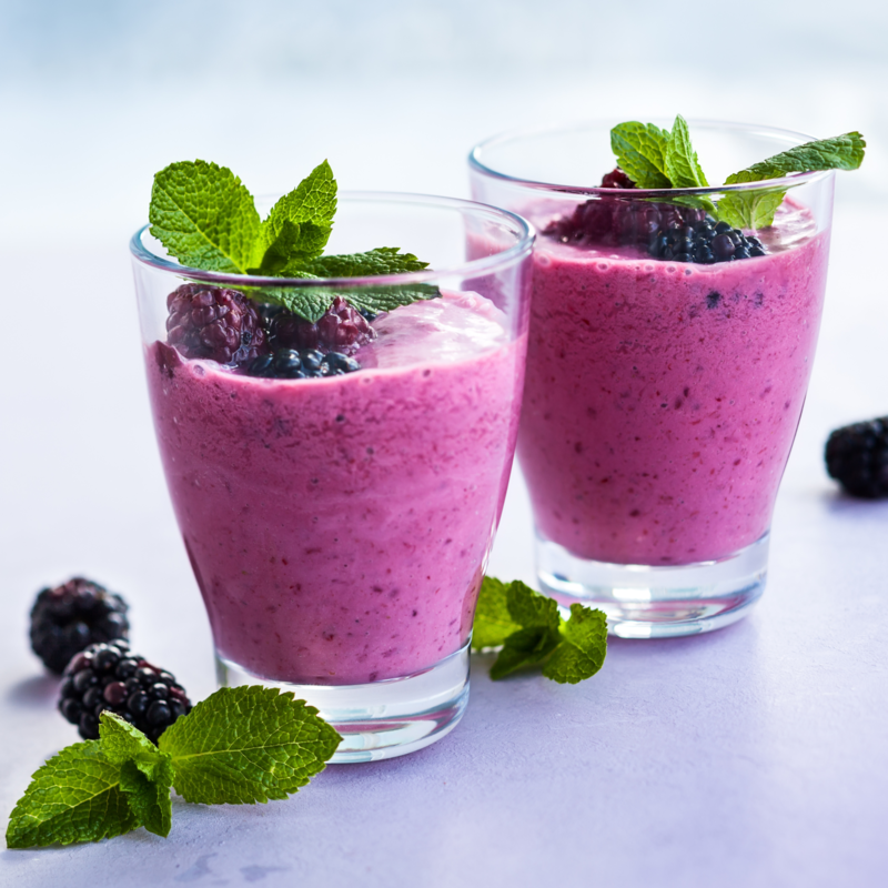 Nutrition Australia's dairy free Berry Delight Smoothie served in glass with fresh blueberry's 