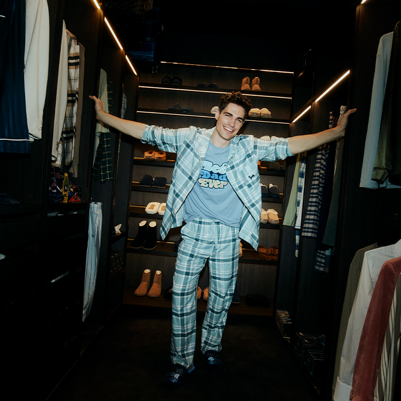 Man wearing Peter Alexander Father's Day pyjamas and slippers standing in a wardrobe