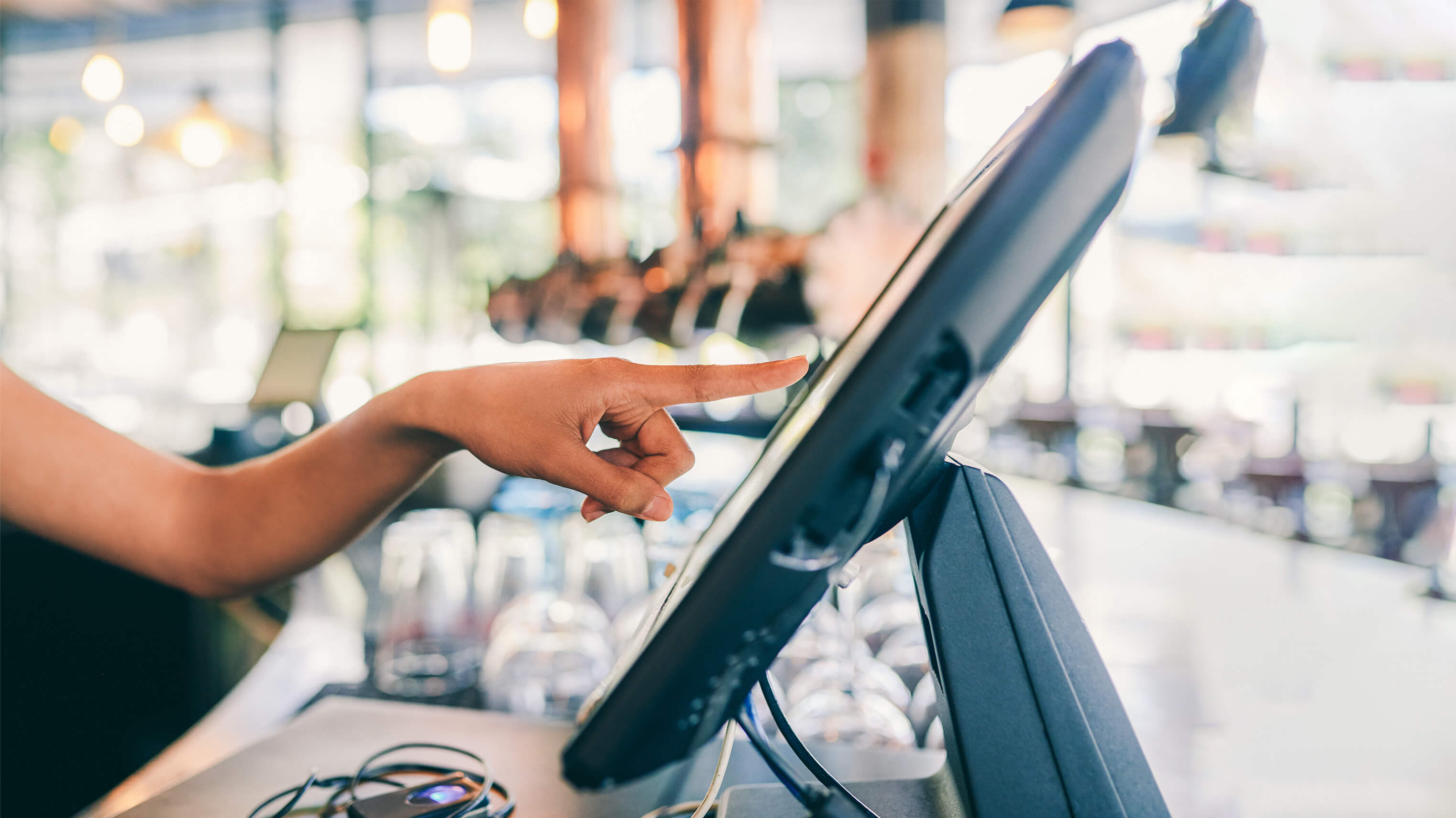 Image of a finger pointing at a computer screen.