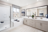 primary bathroom with white countertops and large window