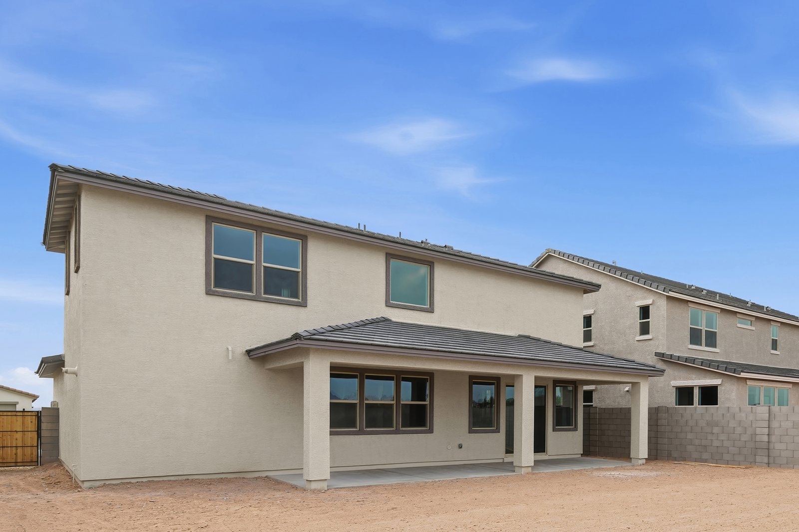 spacious dirt backyard with an extended covered patio