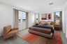 spacious area with a large bed with warm colors and a large rug