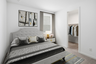 bedroom with a large bed, grey zebra print covers, and large grey rug