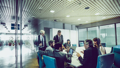 Group of business people in a glass-walled conference room 