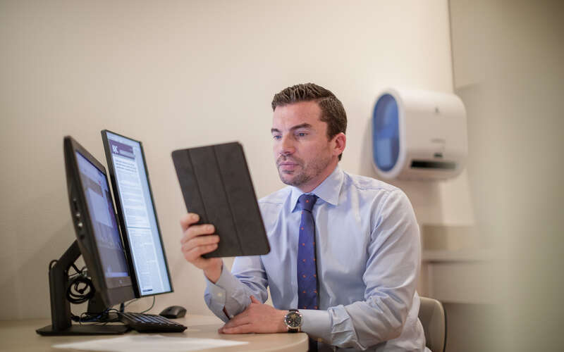 Dr. Philippe Spiess reads on an iPad  