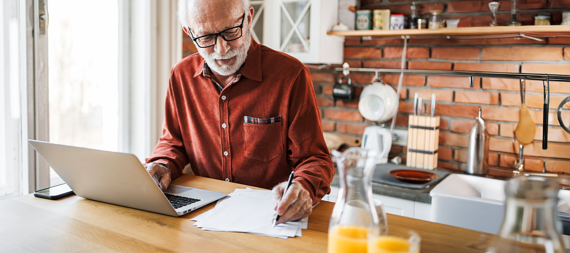 An older homeowner reviewing their expenses