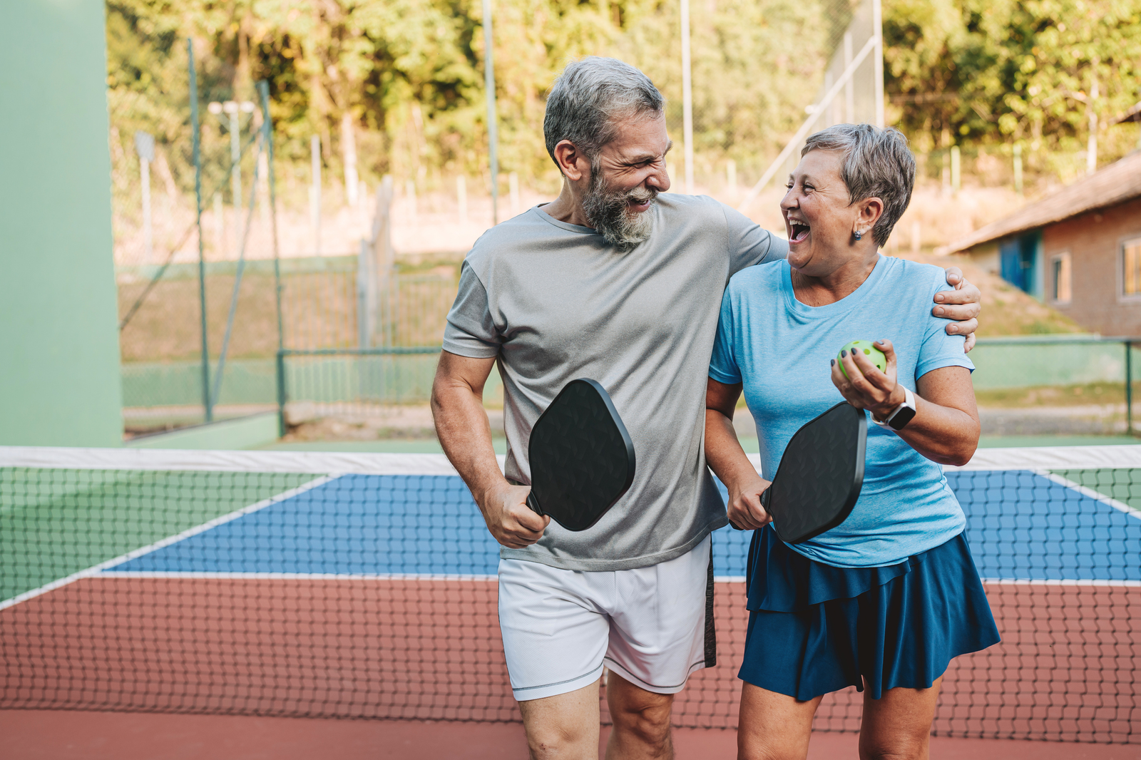 couple laughing on a pickleball court