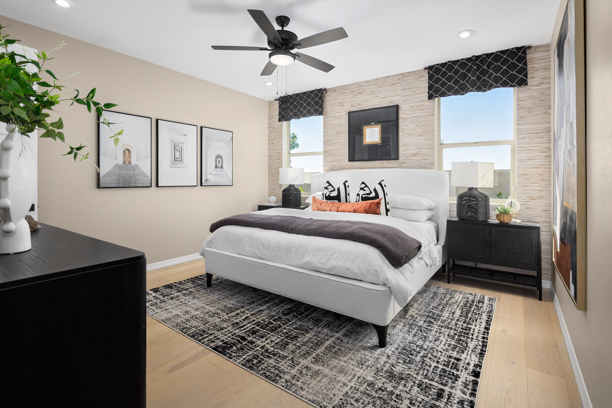 large bed on patterned rug with wood-like flooring