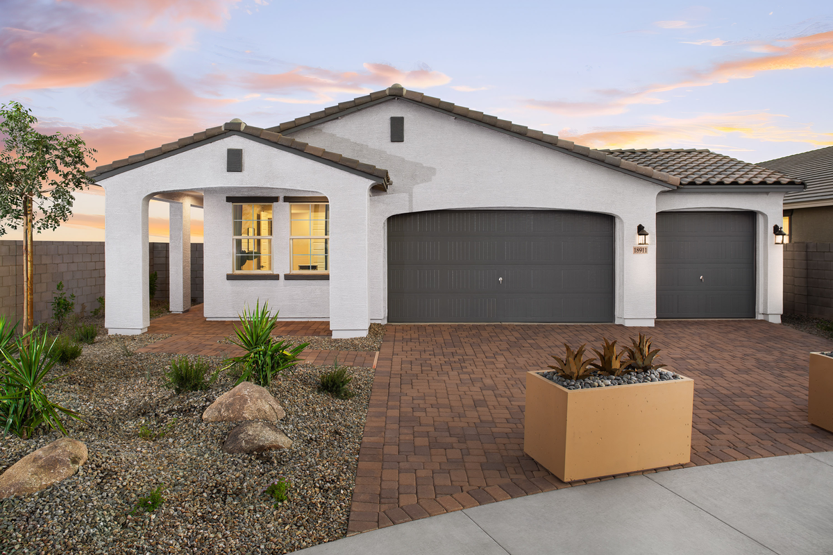 paver driveway with planters and a covered entry