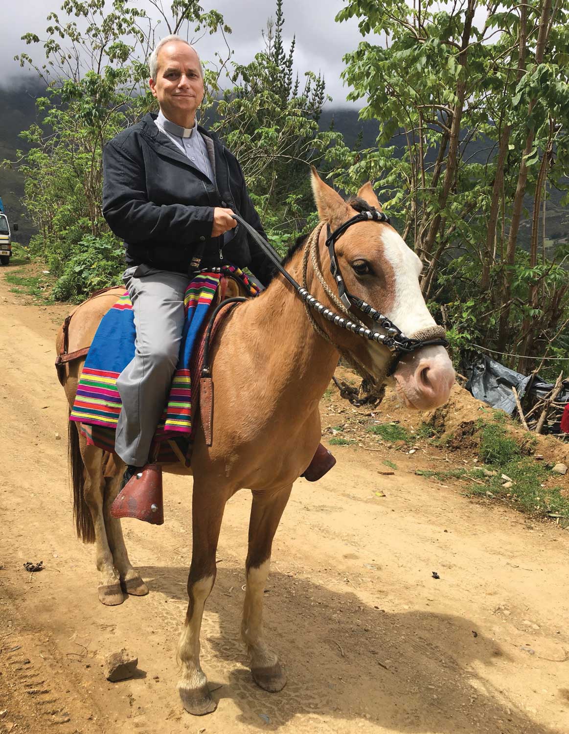 Bishop Robert Prevost of Chiclayo, Peru, rides a horse down a dirt road in October 2017.