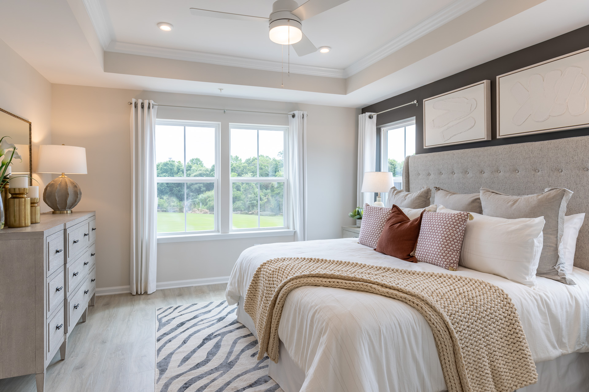 primary suite with a box ceiling and carpet