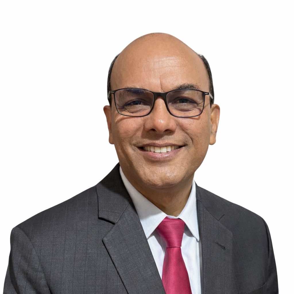 A professional headshot against a white background featuring a smiling man with a bald head and glasses. He is wearing a grey pinstripe suit jacket, a white dress shirt, and a vibrant red tie.