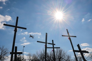 An airplane takes off from Reagan National Airport in Arlington, Va., as a memorial is seen in the foreground.