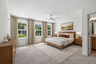 primary suite with a king-size bed and carpet