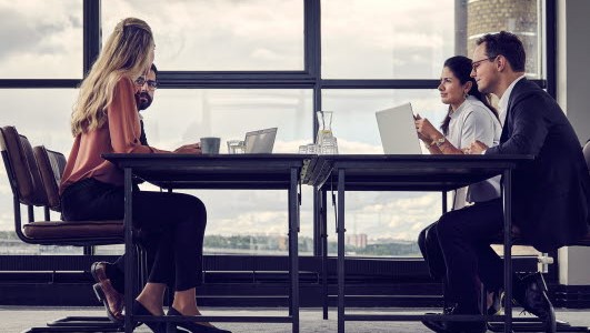 Fire mennesker ved et møtebord