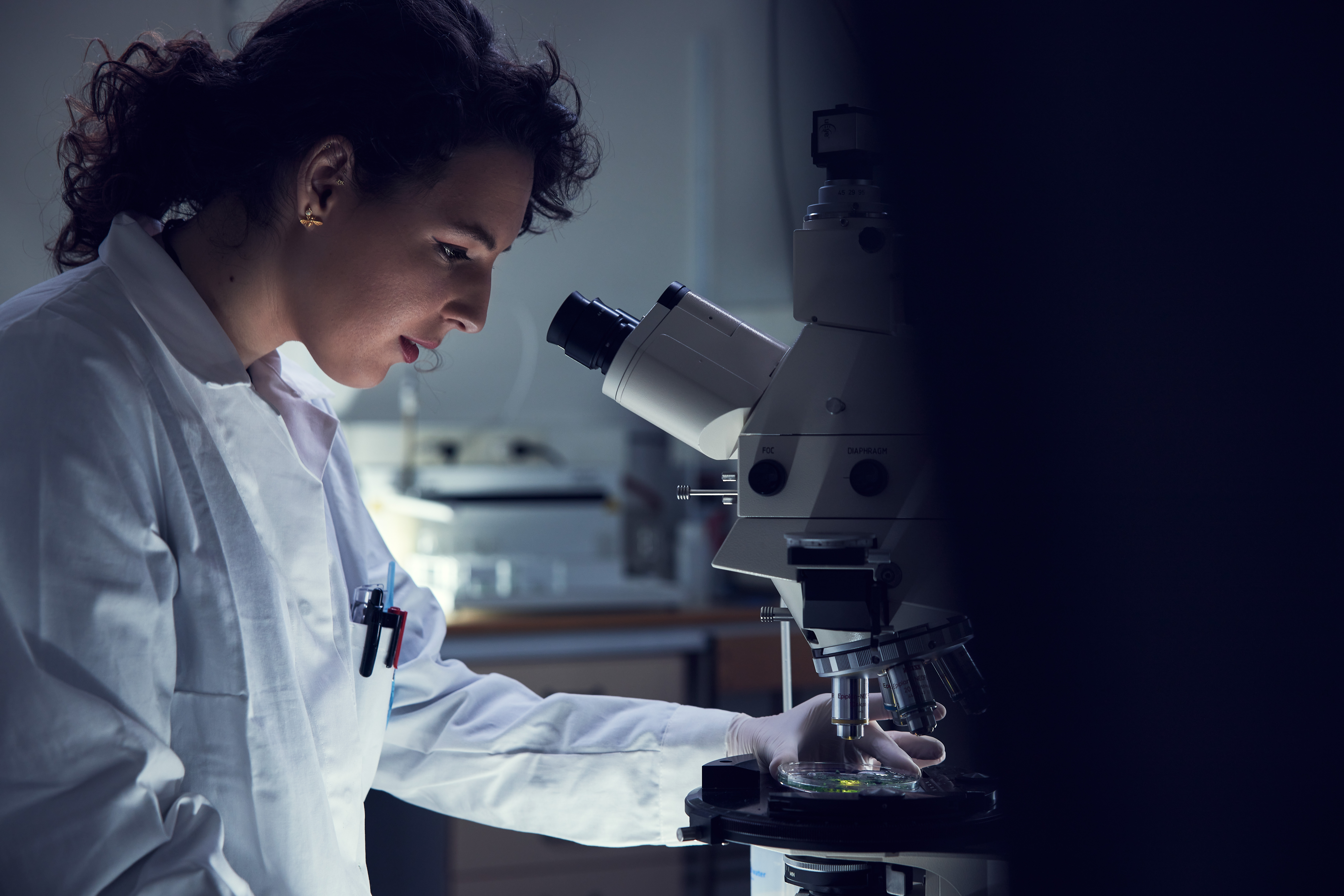Woman in laboratory looking into a microscope