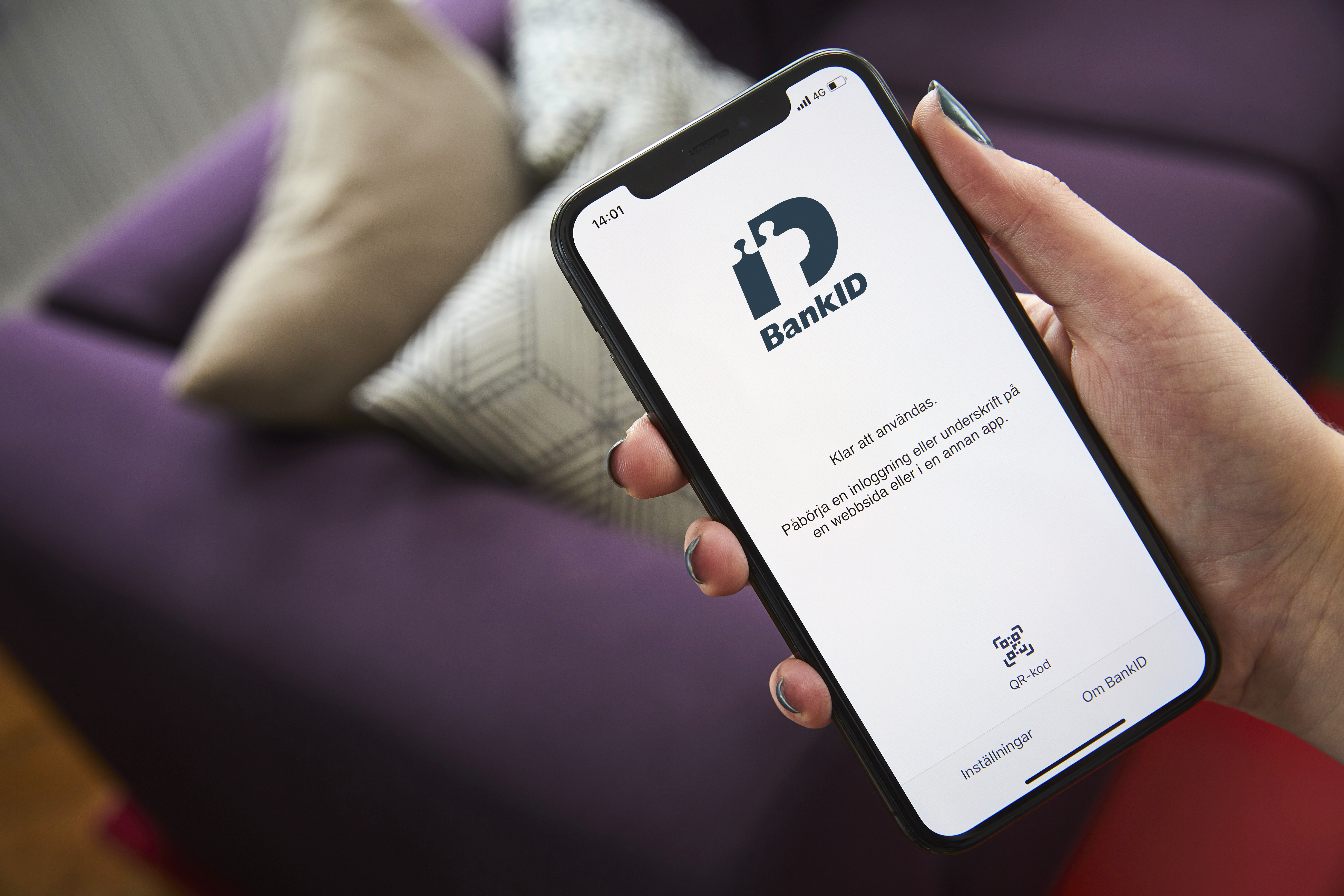 Person som håller i en mobil som visar inloggningssidan till mobilt BankID.