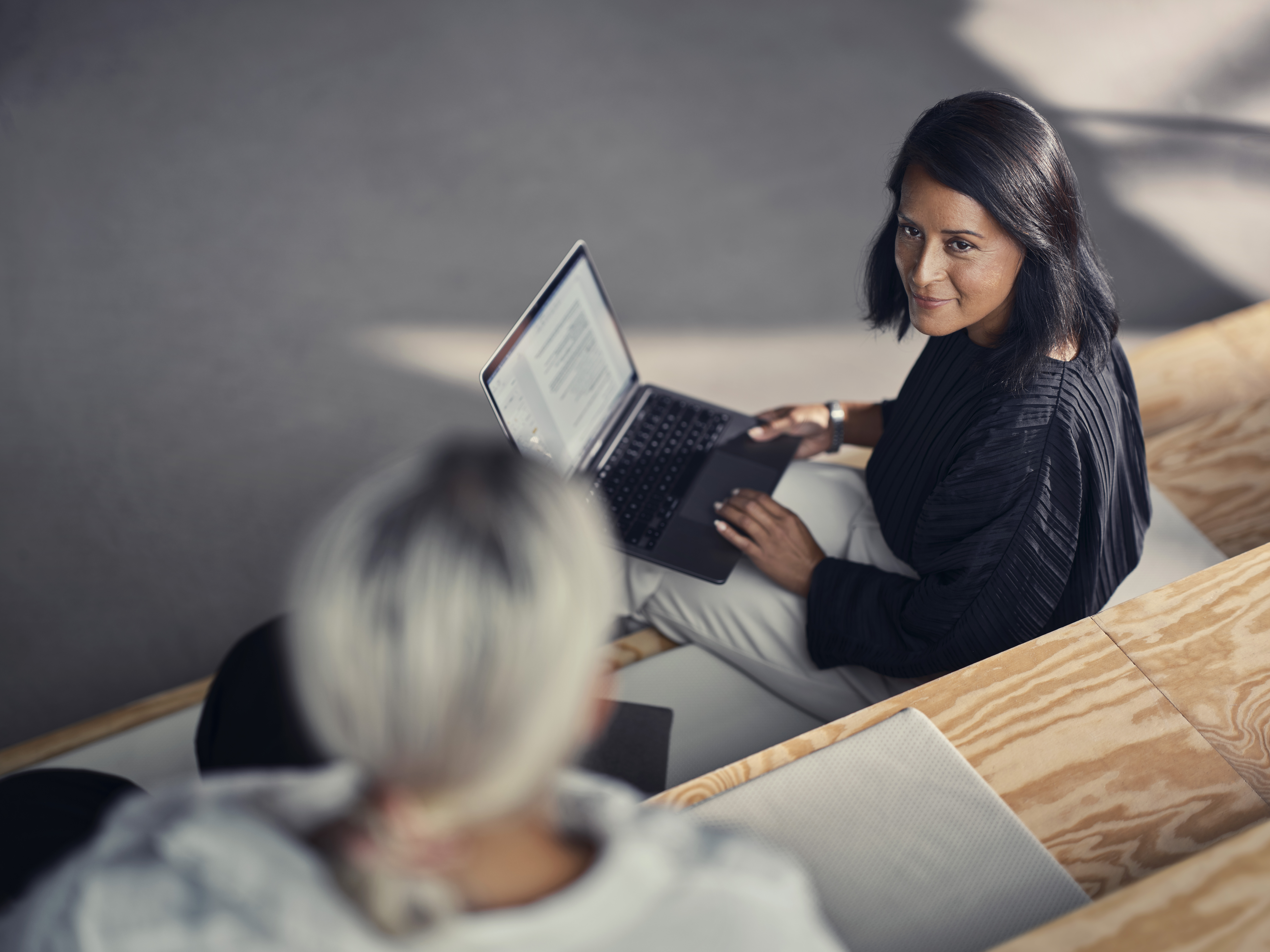 To kvinder i samtale over en laptop