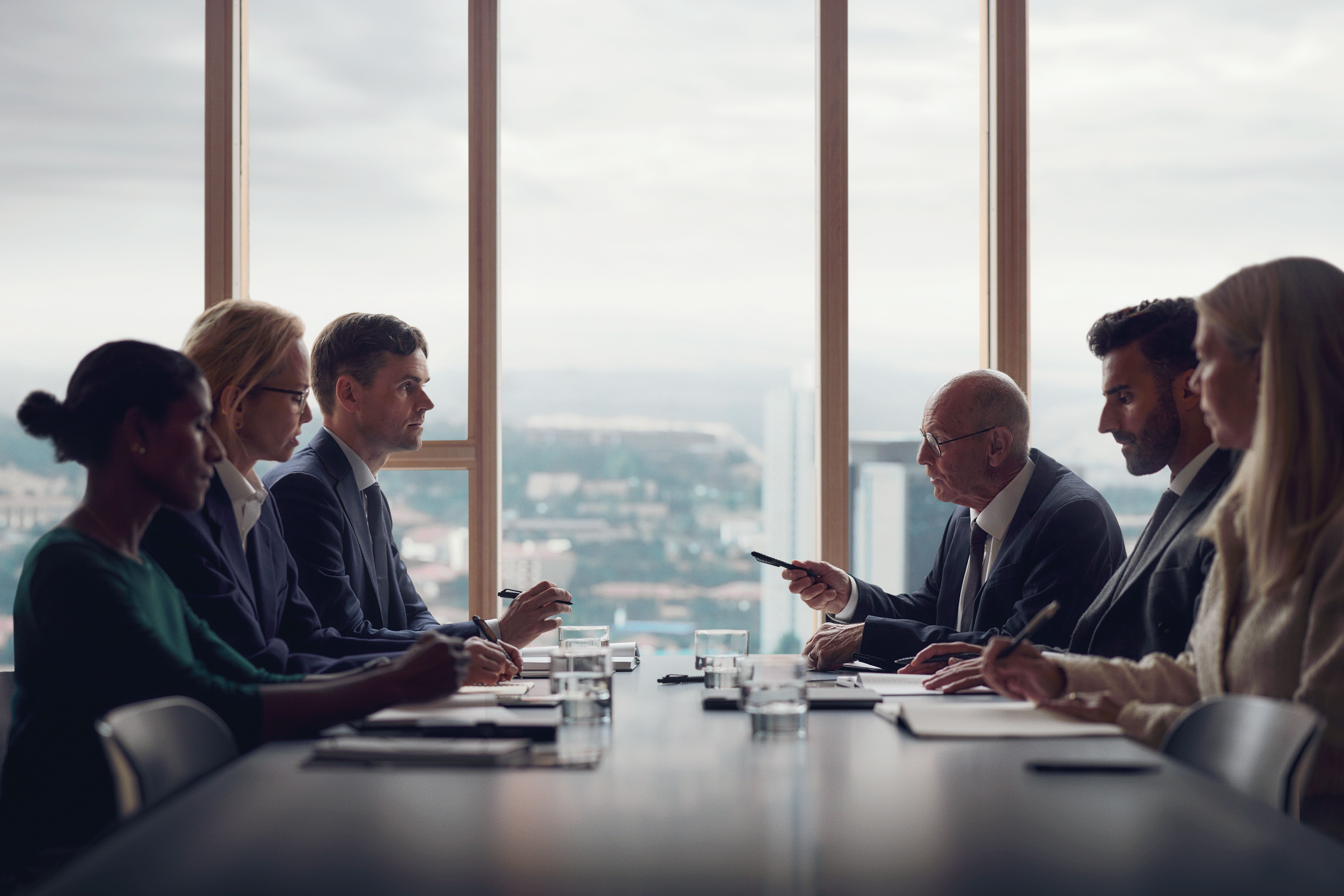Menschen im Gespräch mit Unterlagen an einem Tisch.