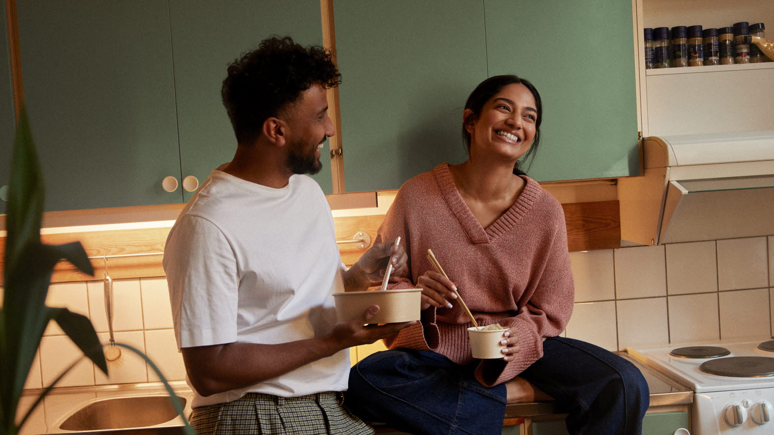 Ett par som sitter i ett kök.