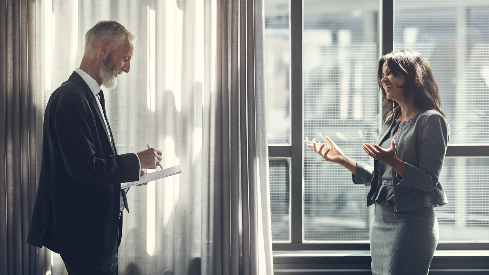Man taking notes and woman in discussion
