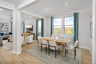 separate dining space with a wooden table and white chairs