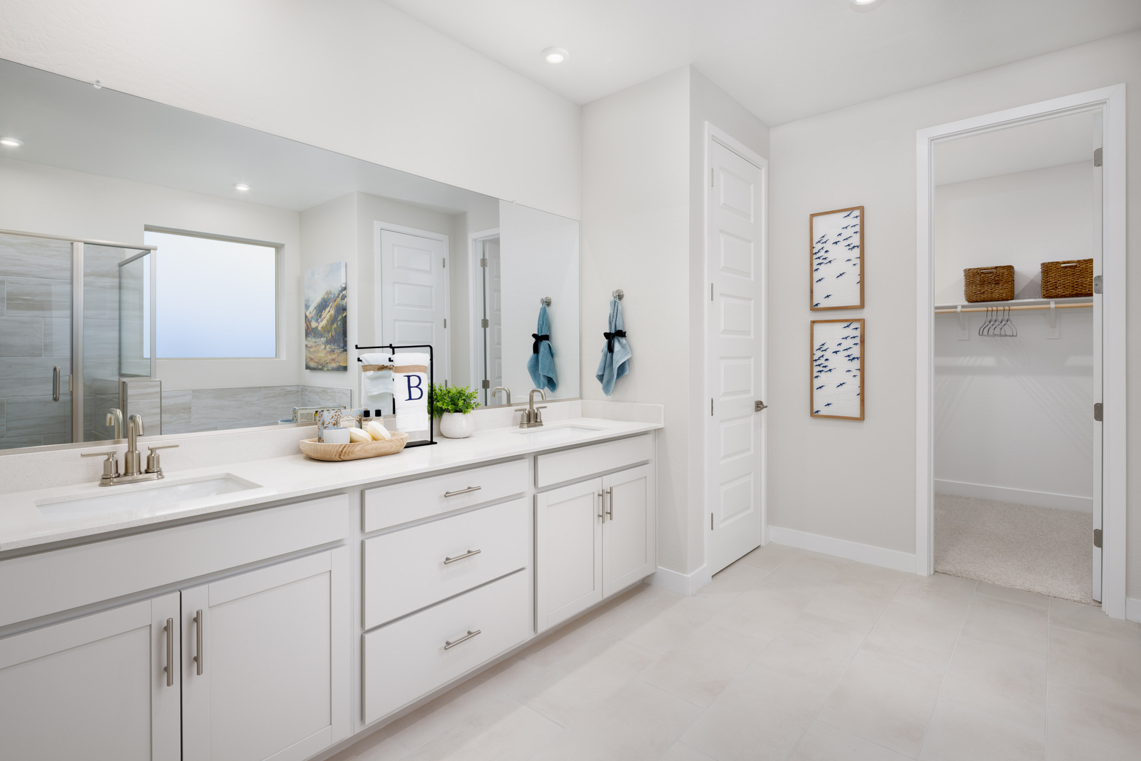 bathroom with light grey cabinets, double sink, and brushed nickel faucets