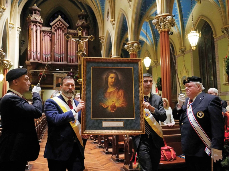 Knights carry the Sacred Heart pilgrim icon into St. Mary&rsquo;s Church