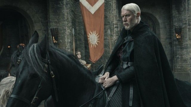 Sam Spruell as Prince Maekar Targaryen riding a black horse through a courtyard in A Knight of the Seven Kingdoms.