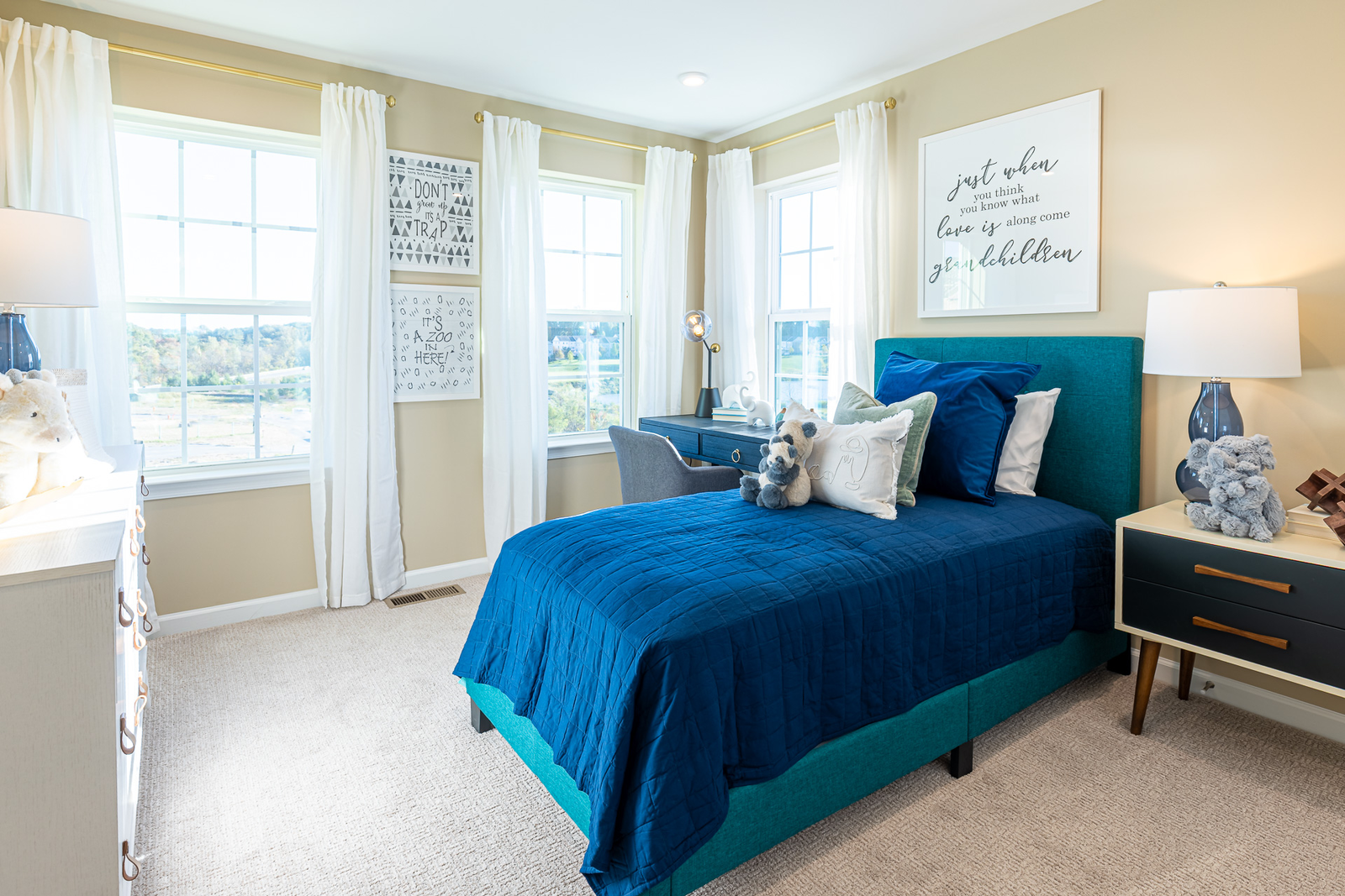 secondary bedroom with 3 large windows and carpet